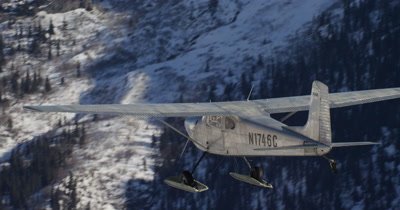 Aerial View of Small Airplane Flying in Alaska Mountains in Winter