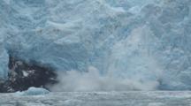 Tidewater Glacier Calves Behind Seals Floating On Ice Bergs