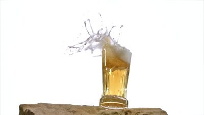 Glass of Beer falling and Splashing on Stone against White Background, Slow motion