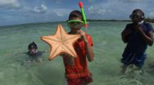 Child Holds Up Sea Star