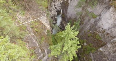 4K aerial over steep very narrow canyon in Rocky Mountains - reverse