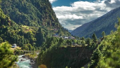 Time-lapse of a Himalayan valley with a river and a small village.