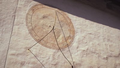 Static shot of a sundial on a wall in Switzerland