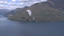 Two Paragliders Fly Over Some Water.