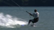 A Kiteboarder Launches From Shore And Falls In The Water.
