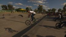 Wide Of Two Bmx Riders Doing Different Stalls At A Skate Park.