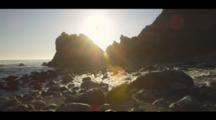 Time-Lapse Of Waves Coming Ashore Along A Rocky Coast, As The Sunsets. Shot Goes From Golden To Dark.
