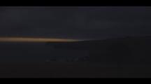 Time-Lapse Of Clouds Moving. Shot Goes From Dark To Light. The Grassy Slopes And Rocky Coves Of The Banks Peninsula Brighten As Sunrise Reveals The South Pacific Ocean.