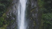 Waterfall Pouring Off Cliff Through Rainforest. Pan From To To Base. South Island, New Zealand.