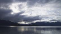 Time Lapse Of Lake Manapouri At Dusk With Dramatic Light On The Water And Mountains.