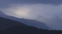 Shot Pans Left To Right. Lake Manapouri At Dusk With Dramatic Light On The Clouds And Mountains.