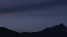 A Crescent Moon Graces The Skyline Above Silhouetted Mountains.
