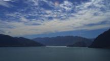 Lake Hawea With Silhouetted Mountains, Blue Sky And Clouds.