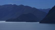 Lake Hawea With Silhouetted Mountains, Blue Sky And Clouds.