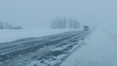 Cars on winter road at blizzard, 4k
