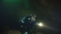 Scuba Diver Explores Underwater Cave By Flashlight