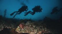 Scuba Divers On Dusk Dive, Silhouetted Over The Usat Liberty Shipwreck At Tulamben, Bali