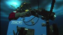 Diver Adjusts Regulator While Holding Camera