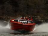 River Flows From Behind Rock, Shotover Jet Boat Appears, Zooms Down River, Trailing Wake