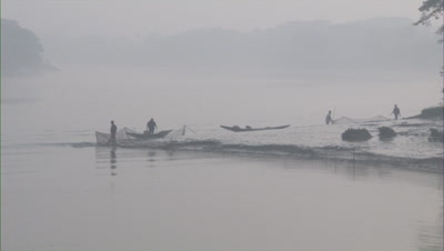 Fishermen Adjusting Fishing Nets In River