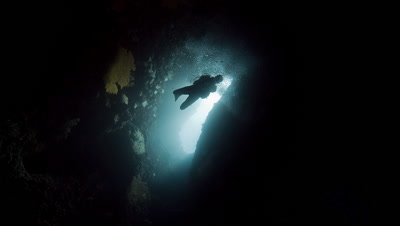 SCUBA DIver descends into and exits underwater cavern