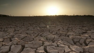 Wide angle sun rises over dry cracked earth