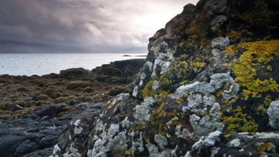 Track back past black rocks on shore of Scottish Loch