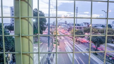 High tracking shot from pedestrian bridge of Manaus traffic from day to night, Brazil