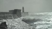 Sea Defences And Storm Waves Over Pier With Lighthouse At End. Porthcawl. Wales. Uk
