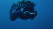 Diver Descends Toward Camera With Light